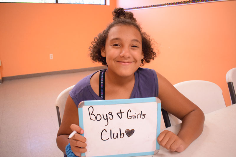 Young girl at the Boys and Girls Club of Bowling Green holding sign for Boys and Girls Club
