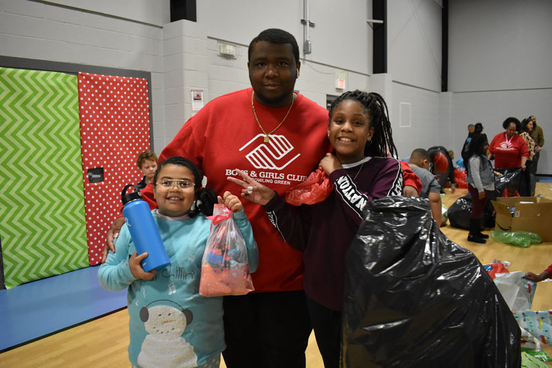 Boys and Girls Club volunteer with two young members at Christmas event